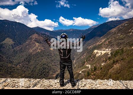 Biker, die Sicherheitsvorrichtungen an der Bergspitze mit hellblauem Himmel am Tag tragen, werden am sela-Pass tawang arunachal pradesh india aufgenommen. Stockfoto