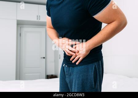 Kaukasischer Mann, der zu Hause an Magenschmerzen leidet. Stockfoto