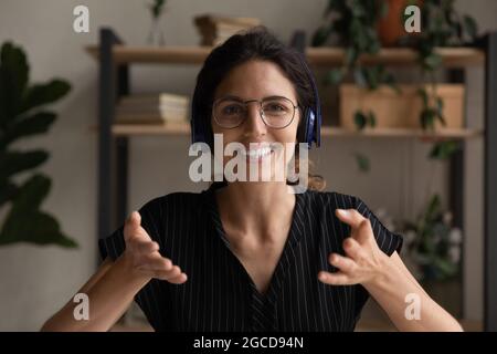 Porträt einer lächelnden Frau in Kopfhörern, die spricht Stockfoto
