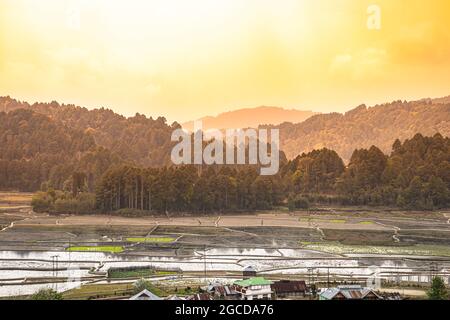 Reisfelder und Dorf auf der Landseite mit Bergkulisse am Morgen Aufnahme in ziro arunachal pradesh india. Stockfoto