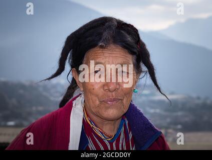 Die alte Dame des Monpa-Stammes in authentischen, traditionellen Kleidporträts zeigt Details aus der Nähe Stockfoto