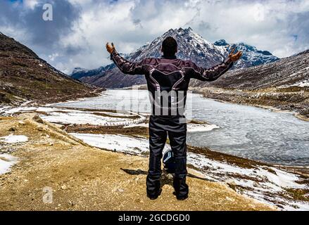 Isolierter junger Mann auf der Bergspitze mit dramatischem Himmel am Tag Bild wird am sela-Pass tawang arunachal pradesh indien aufgenommen. Stockfoto