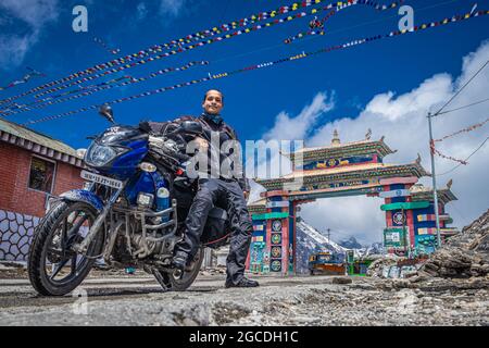 Junger Mann Fahrrad ridder mit seinem geladenen Fahrrad am Bergpass am Tag aus dem niedrigen Winkel Bild aufgenommen sela Pass tawang arunachal pradesh indien am 08. April Stockfoto