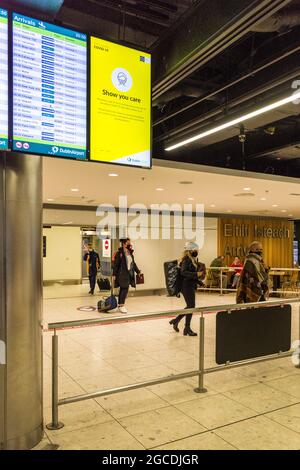 Passagiere mit Masken kommen während der Covid19-Pandemie in Irland am Flughafen Dublin, Terminal 1 an. Stockfoto