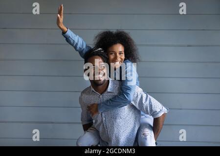 Überglücklich Biracial Frau Huckepack lächelnden ethnischen Mann Stockfoto
