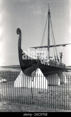 Sechziger Jahre, historische Ansicht des Wikingerschiffs oder Longboats „Hugin“, ausgestellt an der Küste auf der Klippe der Pegwell Bay, Ramsgate, Kent, England, Großbritannien. Ein rekonstruiertes Langschiff, die Hugin, ein Geschenk des dänischen Schenkers zum Gedenken an den 1500. Jahrestag von Hengist und Horsa, Anführer der angelsächsischen Invasion in der nahegelegenen Ebbsfleet, kam 1949 in Viking Bay, Broadstairs an. Es ist eine Nachbildung des Gokstad-Schiffes, ca. 890. Stockfoto