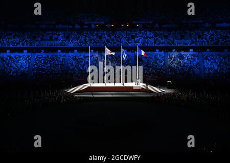 Die japanische, griechische und französische Flagge, die während der Abschlusszeremonie am 17. Tag der Olympischen Spiele 2020 in Tokio, Japan, am Sonntag, dem 08. August, abgebildet ist Stockfoto