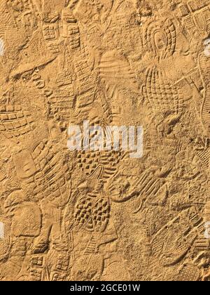 Viele Fußabdruck auf dem Sand Strand Textur Hintergrund. Stockfoto