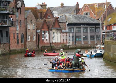 Lewes, Großbritannien. August 2021. Abenteuerlustige Seeleute fahren auf einer 7 Meilen langen Wohltätigkeitsreise entlang des Flusses Ouse von Lewes nach Newhaven in selbstfahrenden Flößen. Das diesjährige Rennthema sind die Olympischen Spiele in Tokio, also müssen die Teilnehmer olympisches Thema sein oder die japanische Kultur feiern. Ein Preis wird an das schnellste Floß des Tages vergeben. Es wird auch Auszeichnungen für das am besten dekorierte Floß, das umweltfreundlichste Floß und den Konstrukteurs-Cup geben. Quelle: James Boardman/Alamy Live News Stockfoto