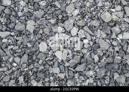 Grauer Boden Steinschutt Hintergrund von vielen kleinen Steinen. Stockfoto