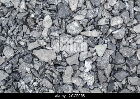Grauer Boden Steinschutt Hintergrund von vielen kleinen Steinen. Stockfoto
