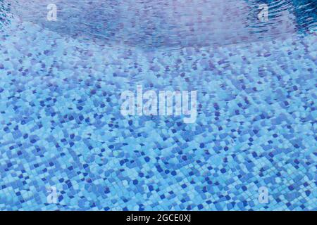 Wellenwasser im Swimmingpool mit Blick auf Unterwasser-Fliesen. Stockfoto