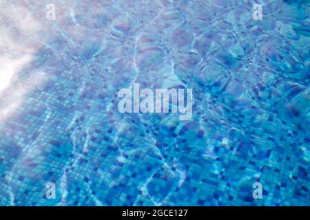 Wellenwasser im Swimmingpool mit Blick auf Unterwasser-Fliesen. Stockfoto