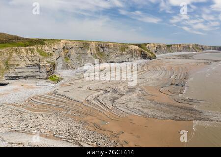 Luftaufnahme von Meeresklippen, Felsformationen und einem Sandstrand (Southerndown, Wales, UK) Stockfoto