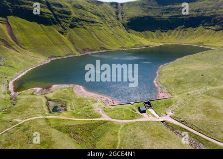 Luftaufnahme eines Sees am Fuße der grünen Berge (Llyn y Fan Fach, Brecon Beacons, Wales) Stockfoto