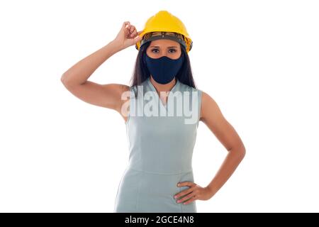 Portrait der asiatischen Ingenieurin Frau mit Helm trägt eine Gesichtsmaske isoliert weißen Hintergrund Stockfoto