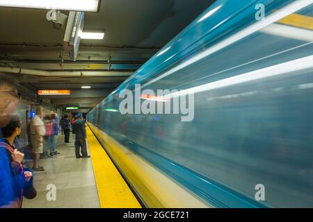 Eine U-Bahn fährt vorbei, während die Leute warten. Die Metro von Montreal (Métro de Montréal) ist eine gummimüde U-Bahn, Montreal, Quebec Stockfoto