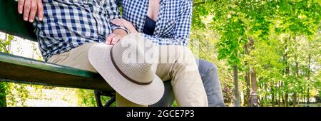 Mann und Frau sitzen auf der Bank im schönen Sommerpark. Entspannen Sie sich Stockfoto
