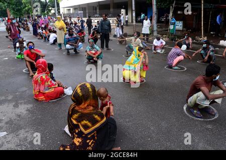 Dhaka, Bangladesch. August 2021. Arme Menschen stehen Schlange, um während der Sperre, die am 8. August 2021 im Poribag-Gebiet in Dhaka, Bangladesch, zur Eindämmung der Ausbreitung des Covid-19-Coronavirus verhängt wurde, Nahrung von der Polizei der Dhaka Metropolitan zu erhalten. Quelle: Mamunur Rashid/Alamy Live News Stockfoto