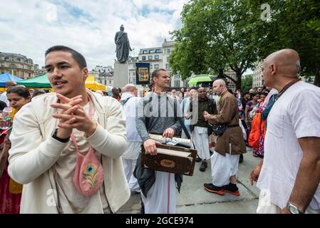 London, Großbritannien. 8. August 2021. Hare Krishna-Anhänger nehmen am Rathayatra-Festival oder dem Chariots-Festival Teil. In diesem Jahr wurde nur ein geschmückter Wagen (normalerweise drei) vom Hyde Park zum Trafalgar Square gerollt. Einmal auf dem Platz, genießen eifrige Anhänger kostenloses vegetarisches Essen und Erfrischungen während des Festivals. Kredit: Stephen Chung / Alamy Live Nachrichten Stockfoto