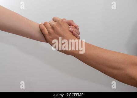 Helfende Hände Mann und Frau halten Hände auf weißem Hintergrund Konzept der Partnerschaft und Teamarbeit . Stockfoto