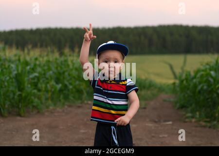 Ein kleiner Junge macht Gesichter und spielt in einem Kornfeld Stockfoto