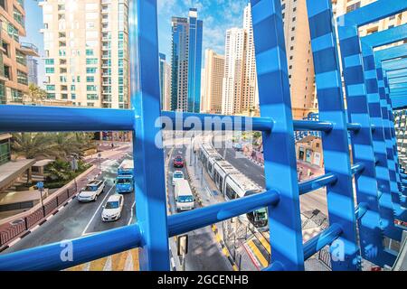 21. Februar 2021, Dubai, VAE: Blick von der Fußgängerbrücke auf die belebte Straßenarterie mit Autos und Straßenbahn in der Dubai Marina Area Stockfoto