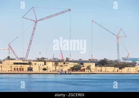 Zahlreiche Industriekrane sind am Bau eines Straßenwechsels und einer Brücke in der Region Bur Dubai und Creek in den Vereinigten Arabischen Emiraten beteiligt Stockfoto