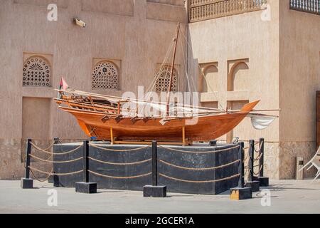 Altes Ruderboot aus Holz, Arba Dhow, auf einem Sockel in der Nähe des Museums in Dubai Creek Stockfoto