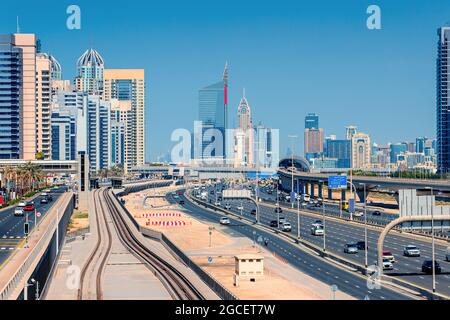 Luftaufnahme der berühmten Sheikh Zayed Road mit starkem Verkehr und Metro- und Straßenbahnschienen sowie zahlreichen Hochhäusern am Horizont. Transport und Stockfoto