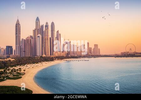 Blick auf den Sonnenuntergang auf die Dubai Marina und die JBR Gegend und das berühmte Riesenrad und die goldenen Sandstrände im Persischen Golf. Urlaub und Ferien in der UA Stockfoto