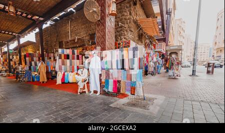 23. Februar 2021, Dubai, VAE: Old Bur Dubai Souk Market in Creek District. Verkäufer und Händler mit Waren, Textilien und Souvenirs Stockfoto