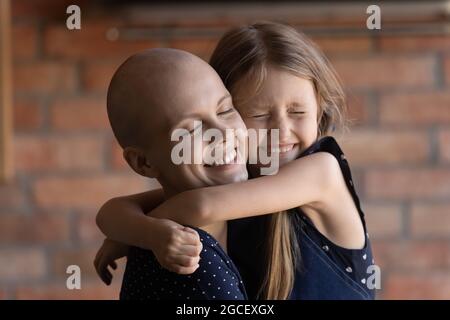 Glücklich Tochter Mädchen umarmt Mutter mit Krebs Stockfoto