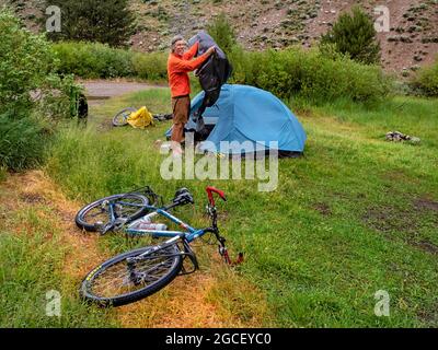 ID00830-00...IDAHO - Einpacken nach einer sehr nassen und stürmischen Nacht entlang der Forest Road 227 auf der Adventure Cycling Idaho Hot Springs Mountain Bike Route Stockfoto