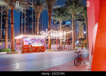 24. Februar 2021, Dubai, VAE: Am Abend kaufen die Menschen leckere Pizza-Fastfood an einem Kiosk-Stand mit Lichtern Stockfoto