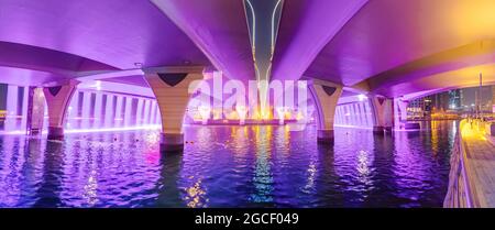 Die Neonbeleuchtung eines künstlichen Wasserfalls von der Brücke über den Dubai-Kanal ist ein beliebter Touristenort, der einen Besuch wert ist Stockfoto