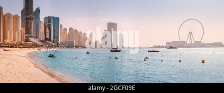 Panoramablick auf den Strand am Persischen Golf und die Bluewaters Island mit dem weltbekannten größten Riesenrad Dubai Eye und zahlreichen Wolkenkratzern mit Ho Stockfoto