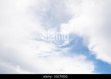 Wolken bedecken fast einen blauen Himmel in diesem Bild, was eine perfekte Passform für die Photoshop Sky Replacement-Funktion ist. Stockfoto