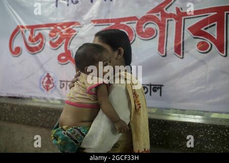 Dhaka, Bangladesch. August 2021. Eine Mutter trägt ihr Kind mit Dengue-Fieber in einem Dhaka-Kinderkrankenhaus. Insgesamt 946 Dengue-Patienten werden derzeit in verschiedenen Krankenhäusern in ganz Bangladesch behandelt. Seit dem 1. August sind in Bangladesch täglich mehr als 200 Dengue-Fälle zu verzeichnen, was die Besorgnis über den bereits überlasteten Gesundheitssektor mit Covid-19-Patienten noch verschärft hat. Kredit: SOPA Images Limited/Alamy Live Nachrichten Stockfoto