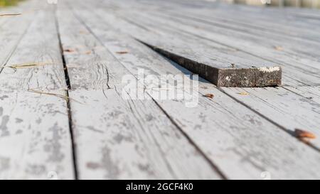 Nahaufnahme eines Holzbodens mit einem hervorragendem Brett. Stockfoto