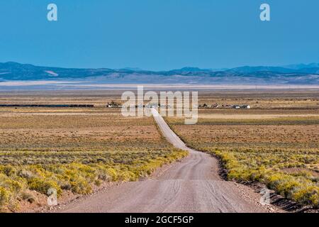 Güterzug nähert sich der Mountain Spring Road in der Siedlung Lund, Escalante Desert, Great Basin Desert, in der Nähe von Cedar City, Utah, USA