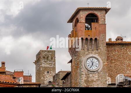 Blick auf den Uhrenturm und die mittelalterliche Festung, auf der die italienische Flagge weht, Passignano sul Trasimeno, Italien Stockfoto