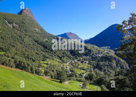 Schöne Aussicht vom Wanderweg Fosseråsa auf Berge, Dörfer und Tallandschaft in der Nähe des Geiranger Fjords, Norwegen. Sommer Tag mit blauem Himmel. Stockfoto