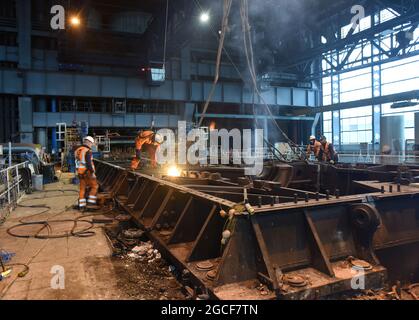 Abbrucharbeiter schneiden Eisen und Stahl mit Acetylenbrenner in der Turbinenhalle des Kraftwerks Buildwas 2019. Stillgelegte Ironbridge Großbritannien Abriss Industriegelände Stockfoto