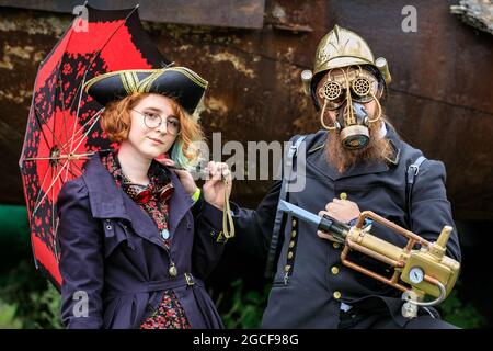 Henrichenburg, Waltrop, Deutschland. August 2021. Zwei Steampunk-Enthusiasten und Darsteller in ihren fabelhaften Outfits. Volle Kraft voraus! Steampunk-Fans und Besucher, viele davon in voller retro-futuristischer Optik, treffen sich zum sencond day des´Steampunk Jubilee Market´ Festivals am historischen Wahrzeichen Henrichenburg-Bootsklift auf dem Dortmund-Ems-Kanal, heute ein Industriedenkmal. Die alten Strukturen und Boote bilden eine stimmungsvolle Kulisse für das Outdoor-Festival. Kredit: Imageplotter/Alamy Live Nachrichten Stockfoto