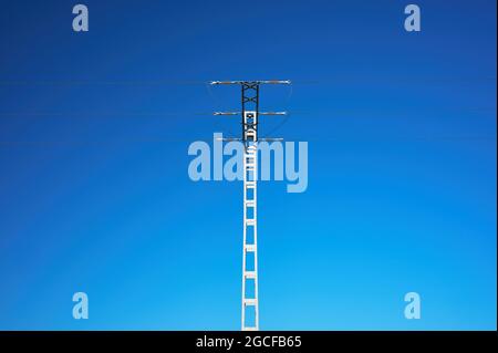 Detail eines Stromkabel-Leitpols vor einem blauen Himmel Hintergrund Stockfoto