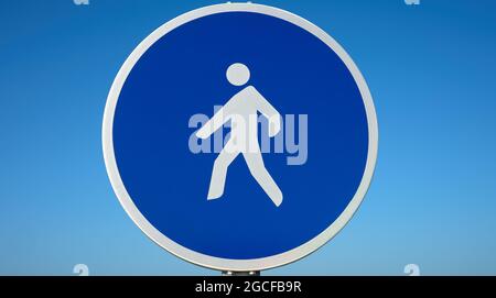 Detail eines runden blauen Verkehrszeichens, das auf eine Fußgängerstraße hinweist Stockfoto