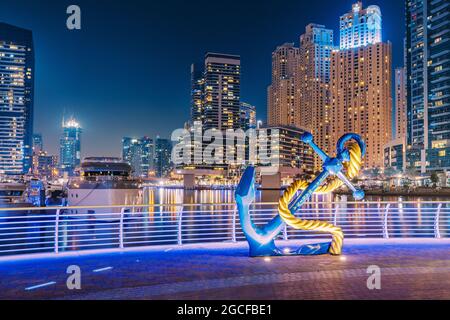 25. Februar 2021, VAE, Dubai: Dekorative Statue eines Yachtankers in der Marina vor dem Hintergrund der Bucht und zahlreichen Wolkenkratzern und Hotels Stockfoto