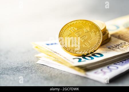 Euro-Banknoten und Bitcoins. Münzen einer Kryptowährung. Stockfoto