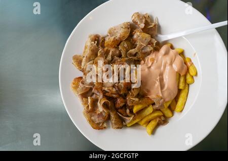 Döner-Kebab-Fleisch aus einer türkischen Rotisserie mit pommes Frites und Cocktailsauce, Fast Food auf einem weißen Teller, Kopierraum, Blick von oben, ausgewählter FOC Stockfoto